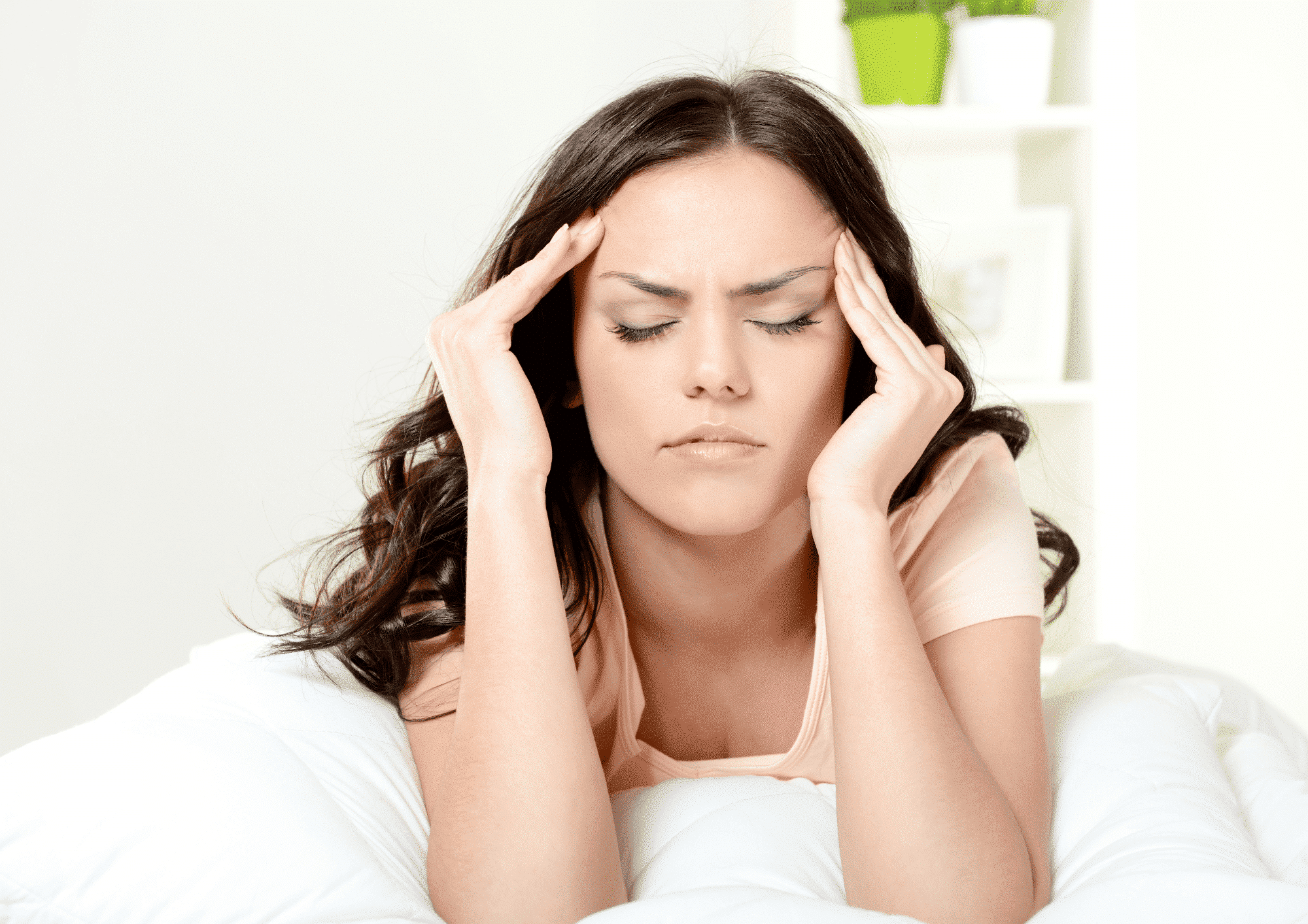 A woman holds her ill head with her hands and needs treatment by Botox For Migraines