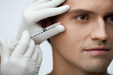 Man`s face gets botox injection for men near the eye