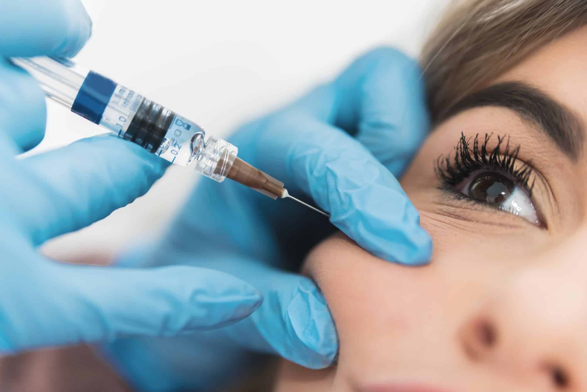 filler injection being administeder into a woman's cheek