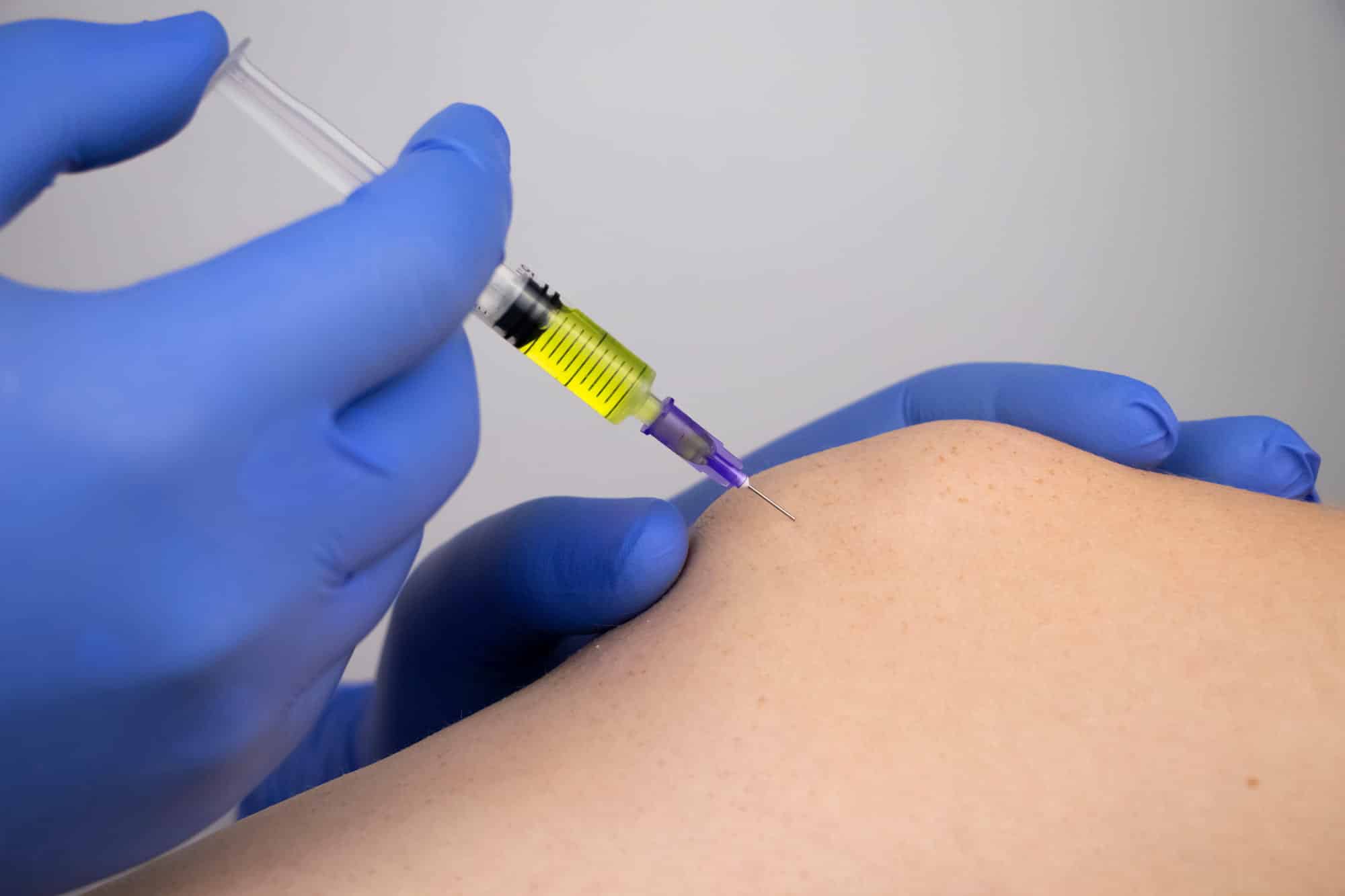 doctor injecting a patient's knee