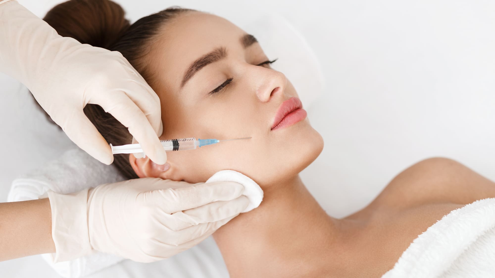 woman getting dermal filler injection in her cheek