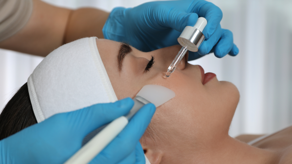 A practitioner applies  biorepeel treatment on the patient’s face, spreading it with a specific brush.