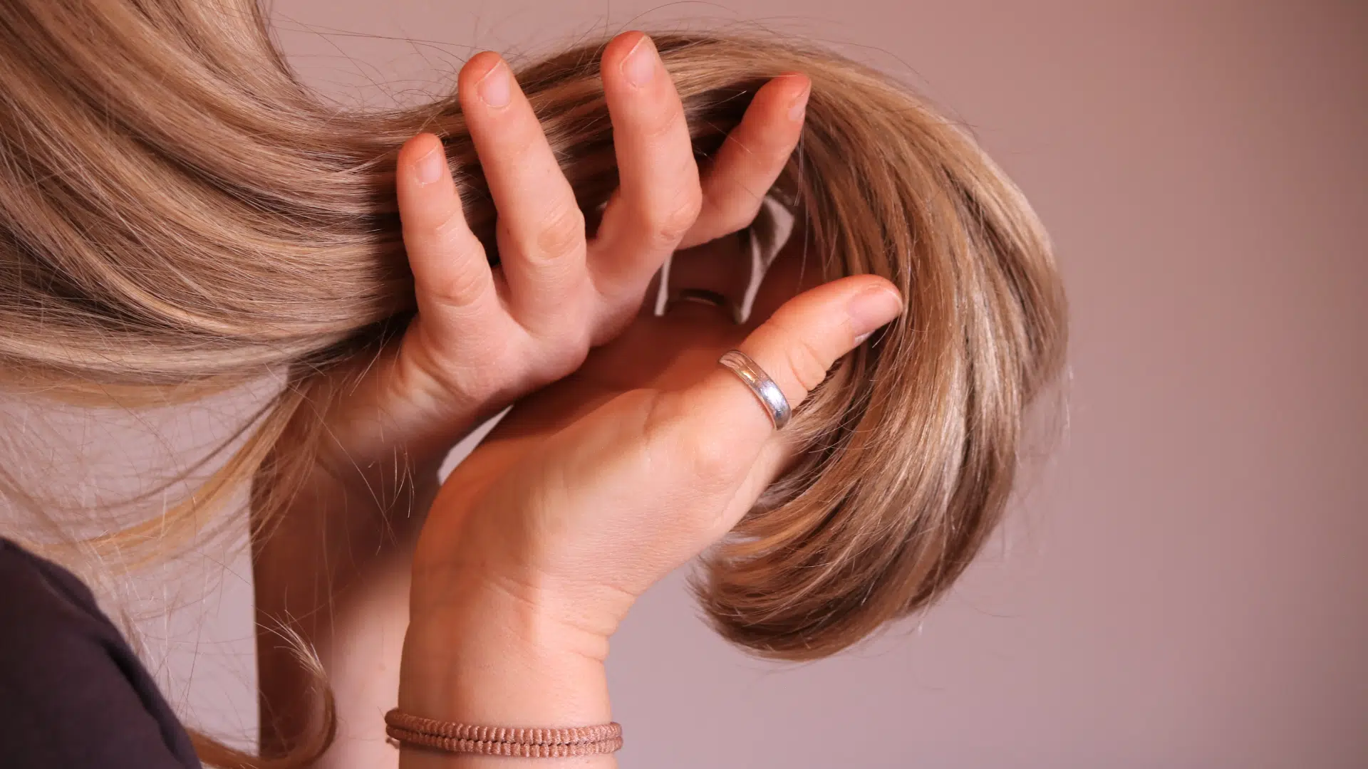 A woman holding her bouncy and healthy hair.