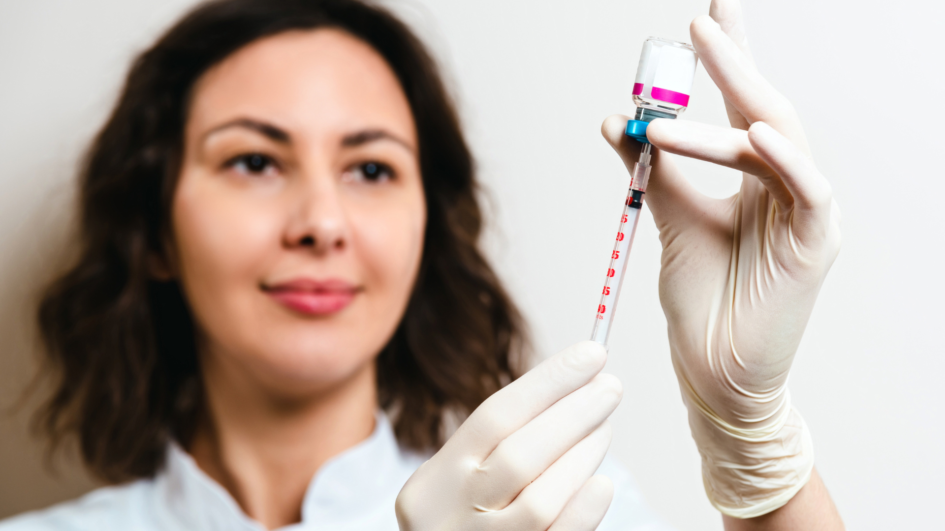 A medical professional preparing the injection for a cosmetic treatment.