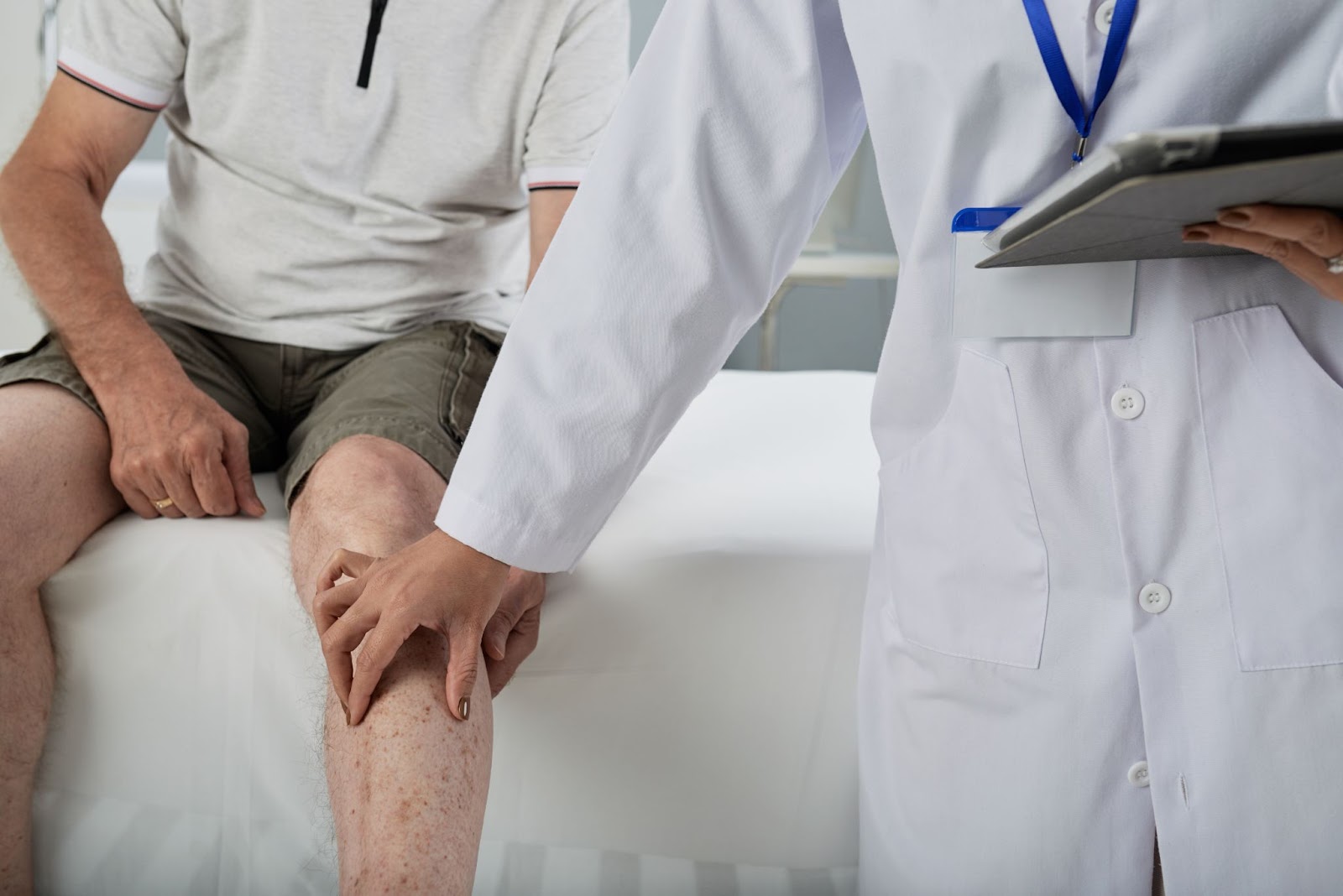 A medical practitioner assessing the patient's knee.