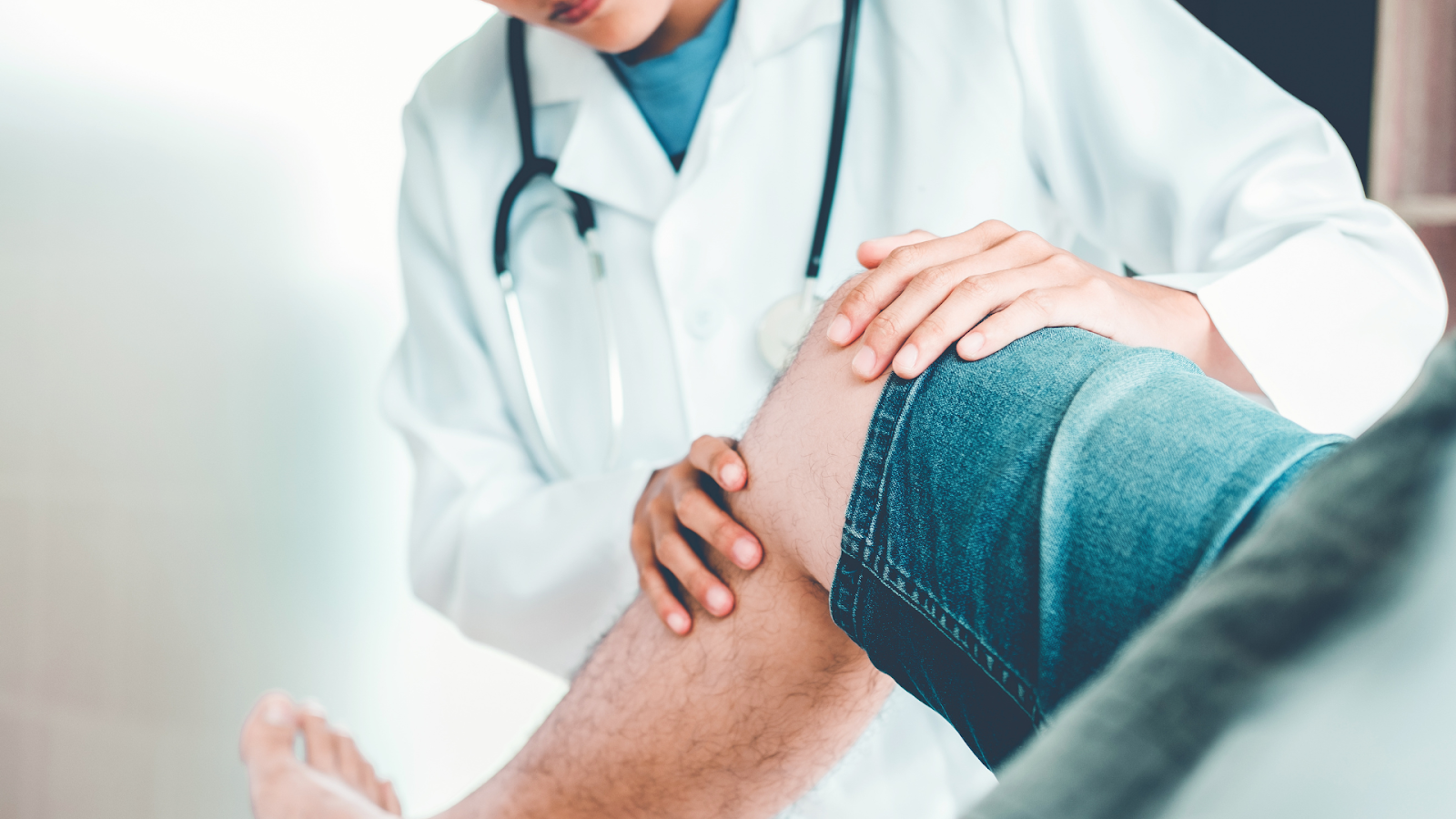 A medical professional examining the knee of the patient.