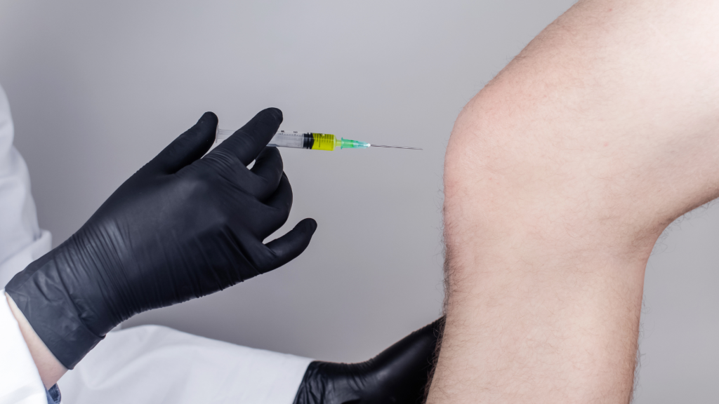 A healthcare provider administering an injection to a patient's knee joint.