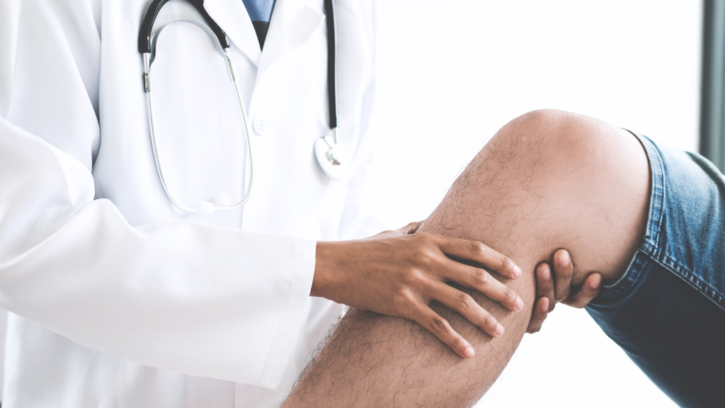 A medical professional examining the knee of a patient.