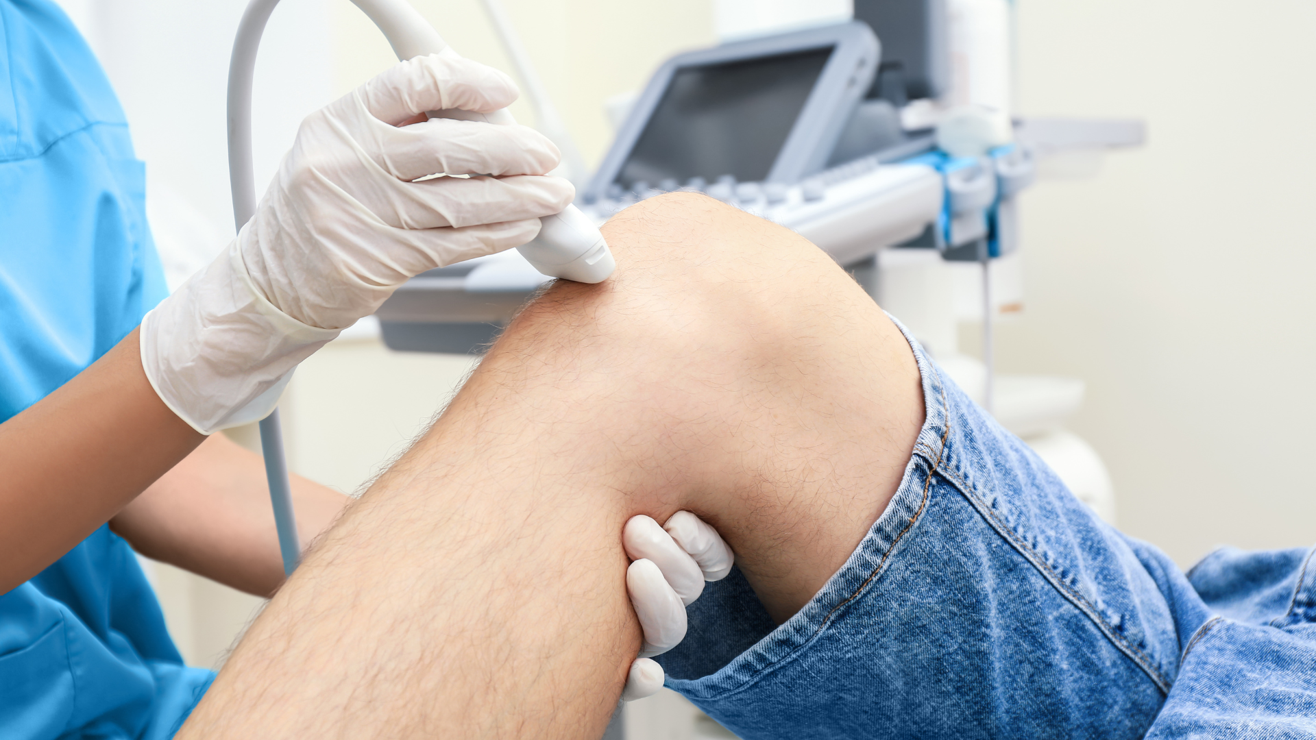 A healthcare provider examining the knee of a patient.