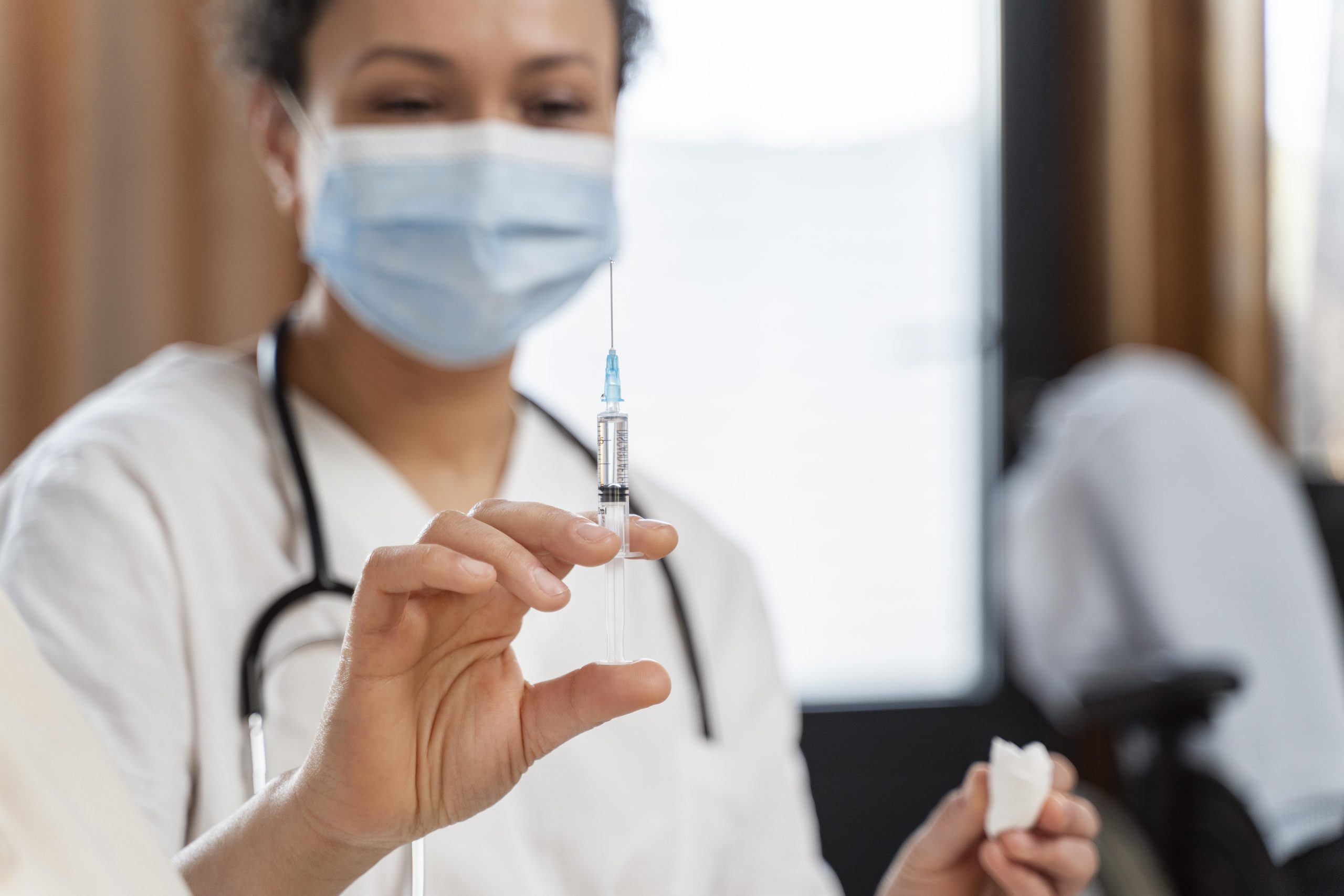 A medical professional preparing an injection for a patient.