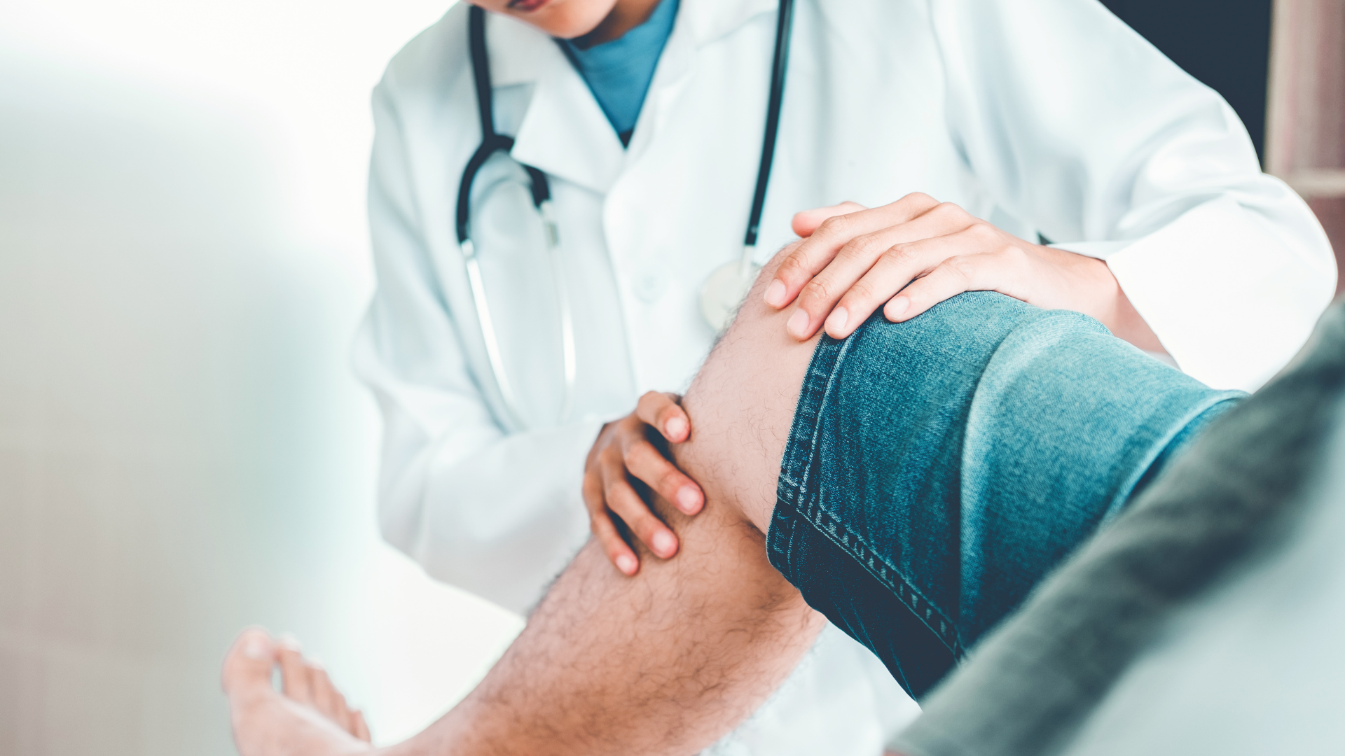 A medical professional examining the knee of the patient.