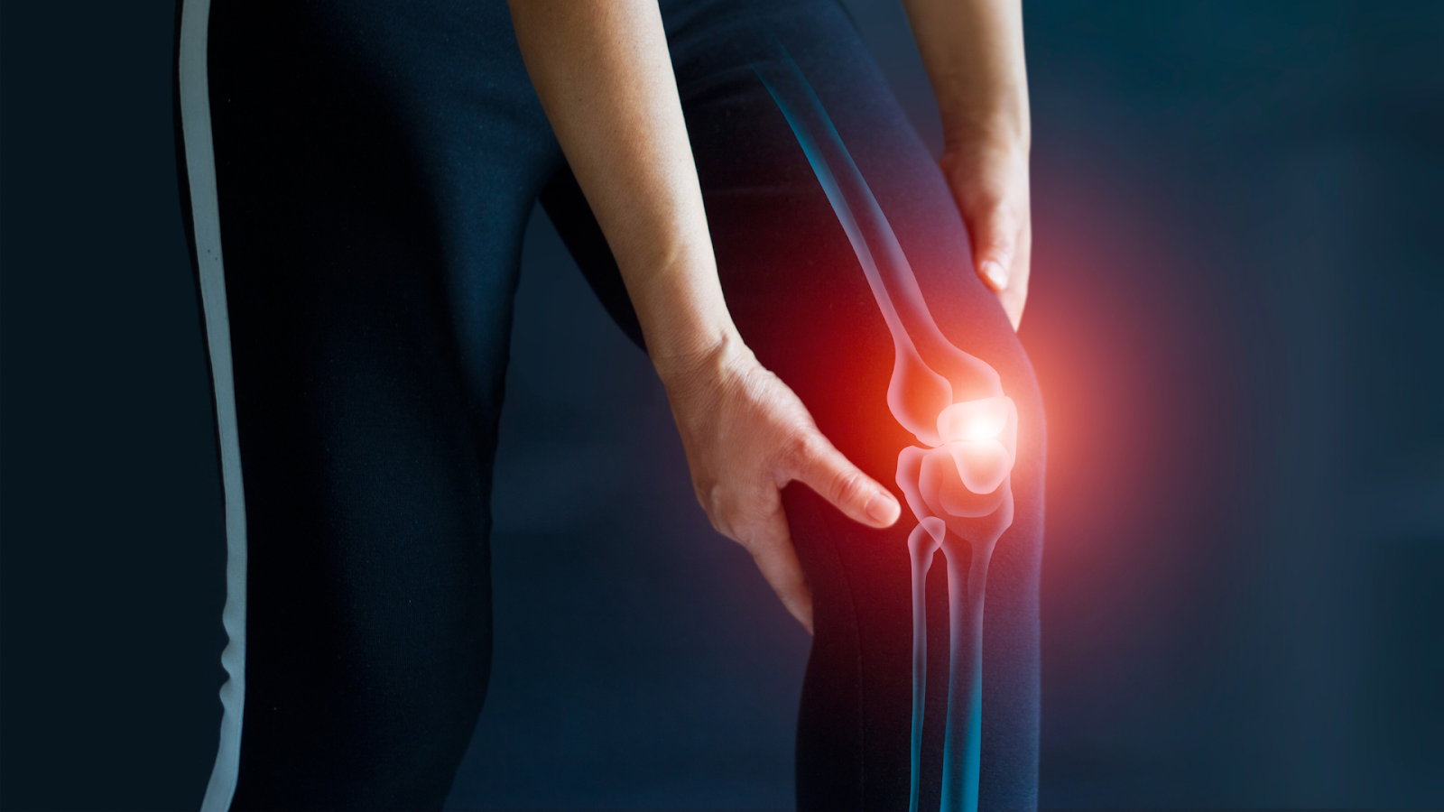 An individual holding their knee while dealing with knee pain.