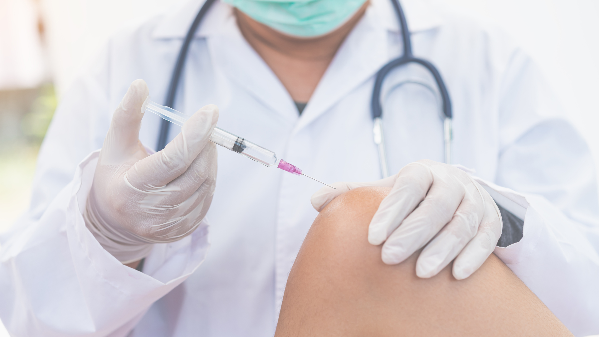 A medical professional administering a knee injection.