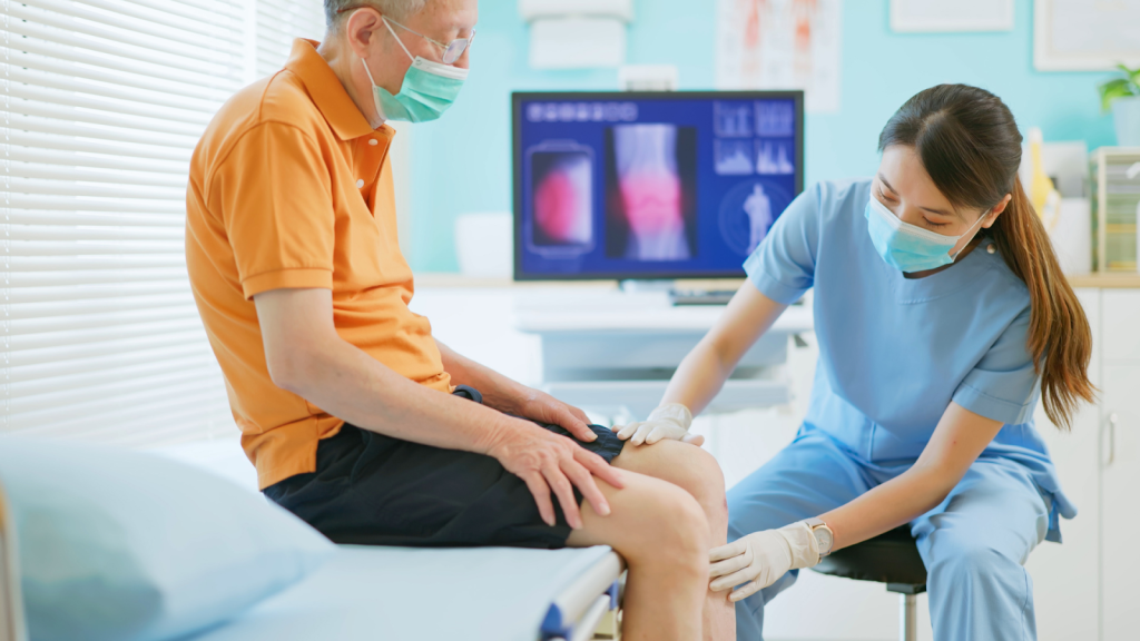 A medical professional examining an older individual's knee.