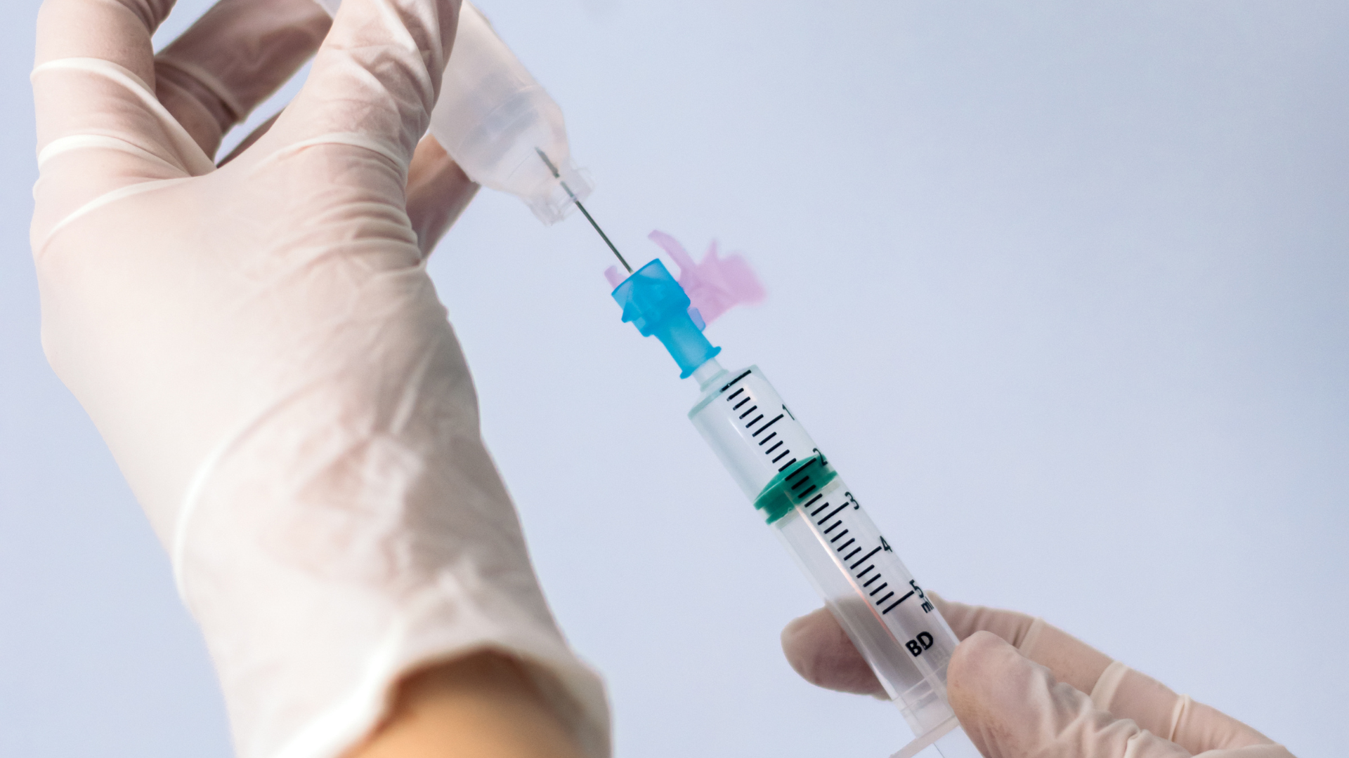 A medical expert preparing a syringe for injection.