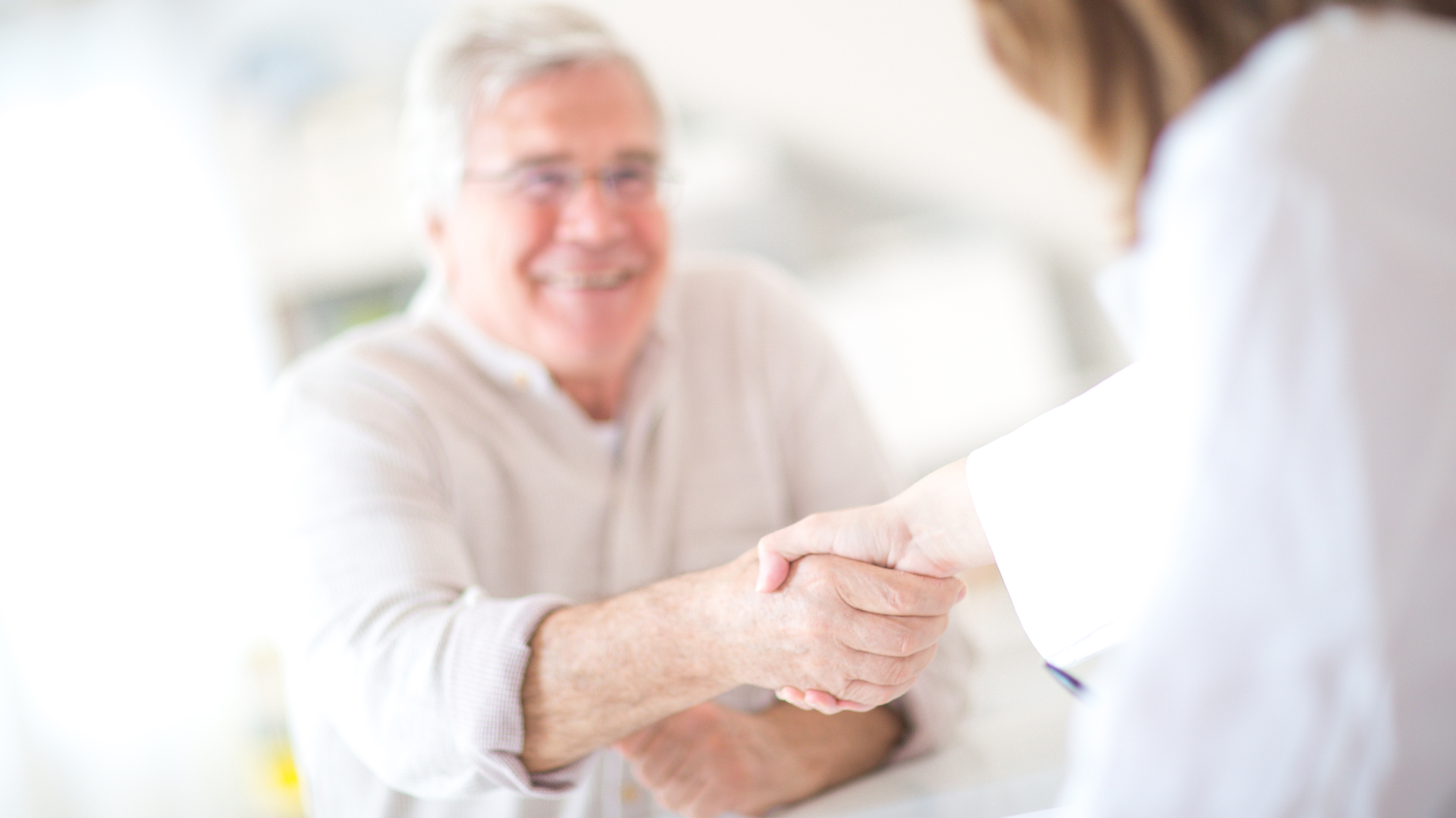 An individual satisfied with the treatment and shaking hands with the doctor.