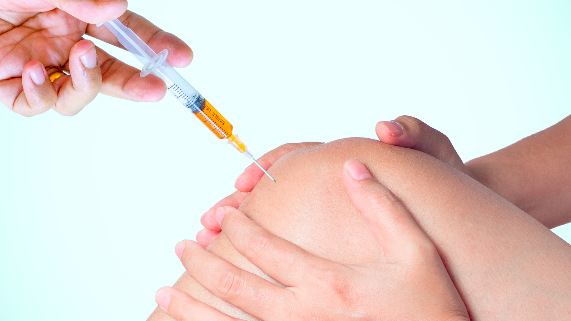 A healthcare provider administering an injection into the patient's knee.