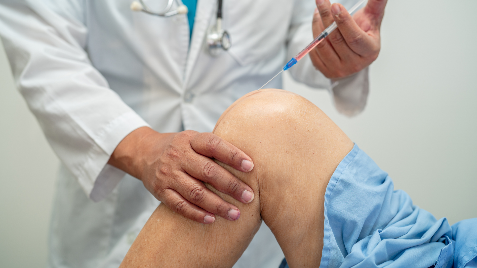 A medical professional injecting medicine into a patient's knee.