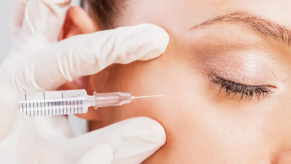 A medical professional administering an injection on the patient's under eyes area.