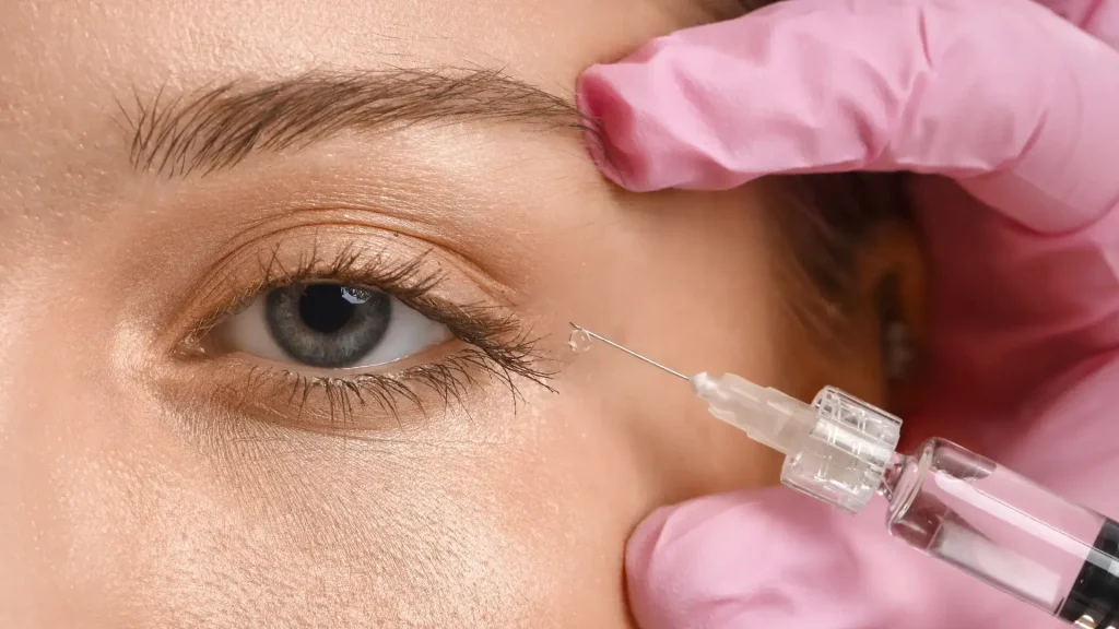 A medical professional administering an injection on the eye corners.