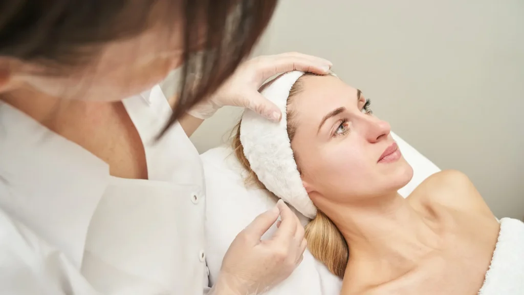 A medical professional assessing a patient's face.