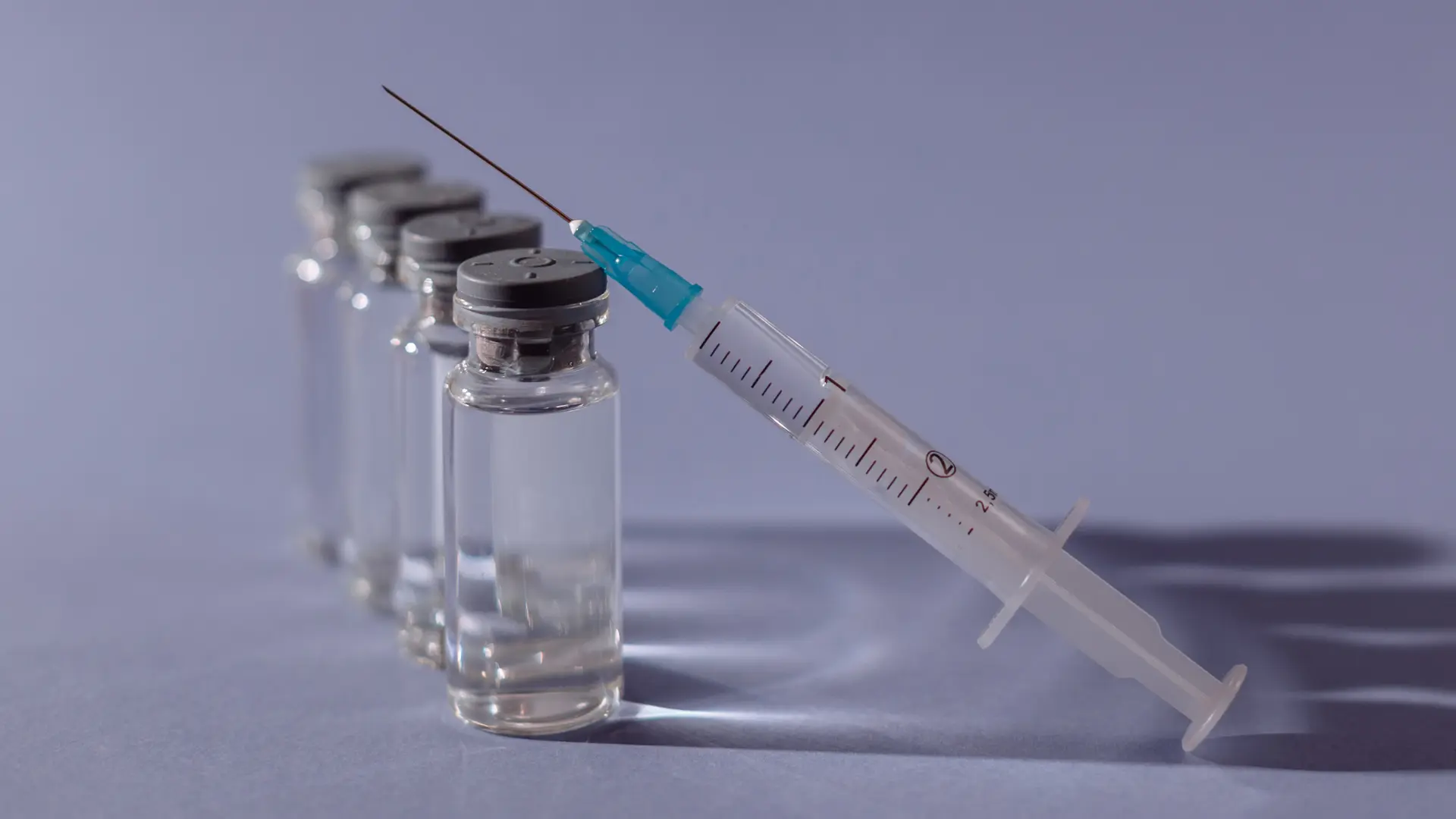 A medical syringe with several medical solution vials.