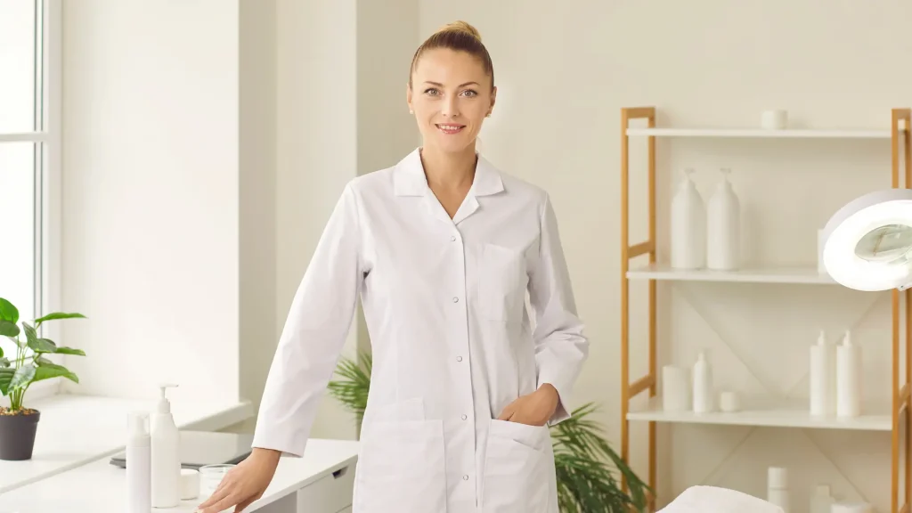 A medical professional standing while smiling in their clinic.