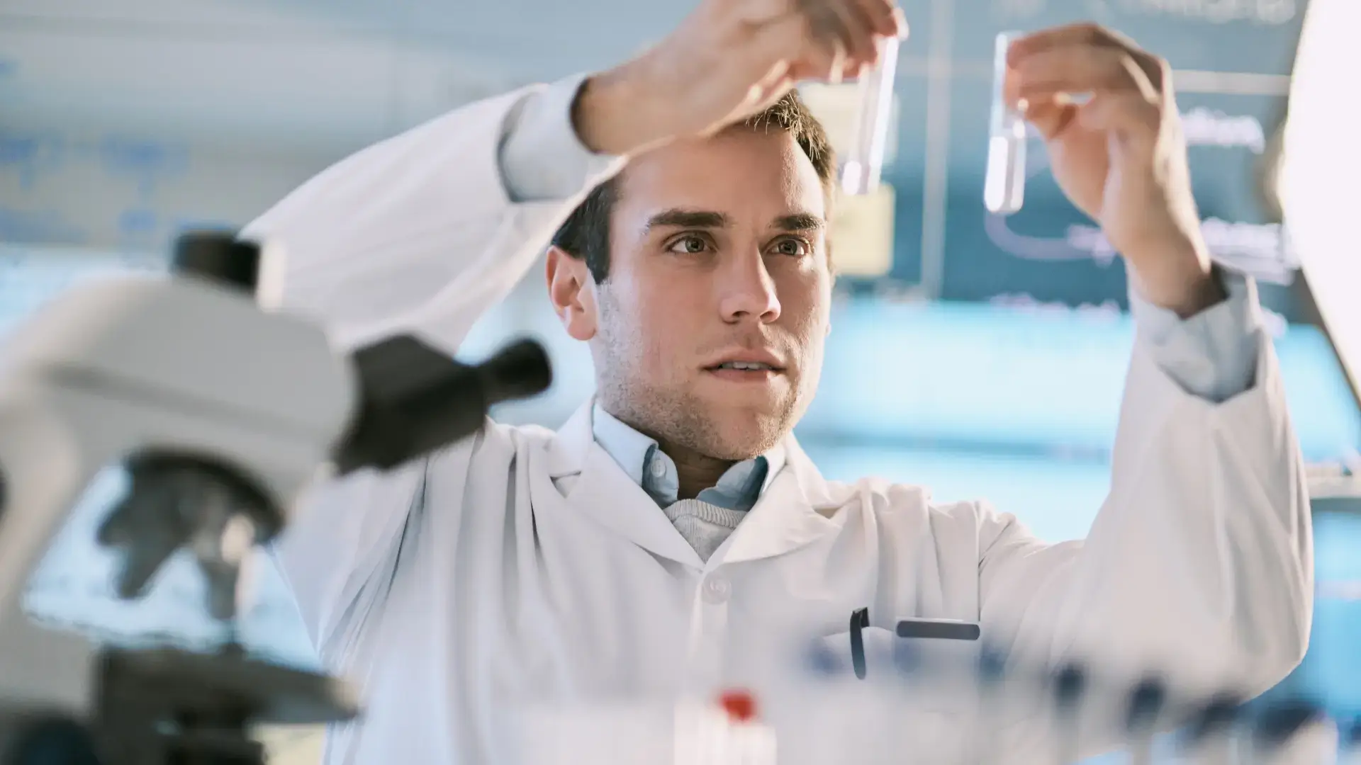 A medical expert examining two different solutions in a test tube.