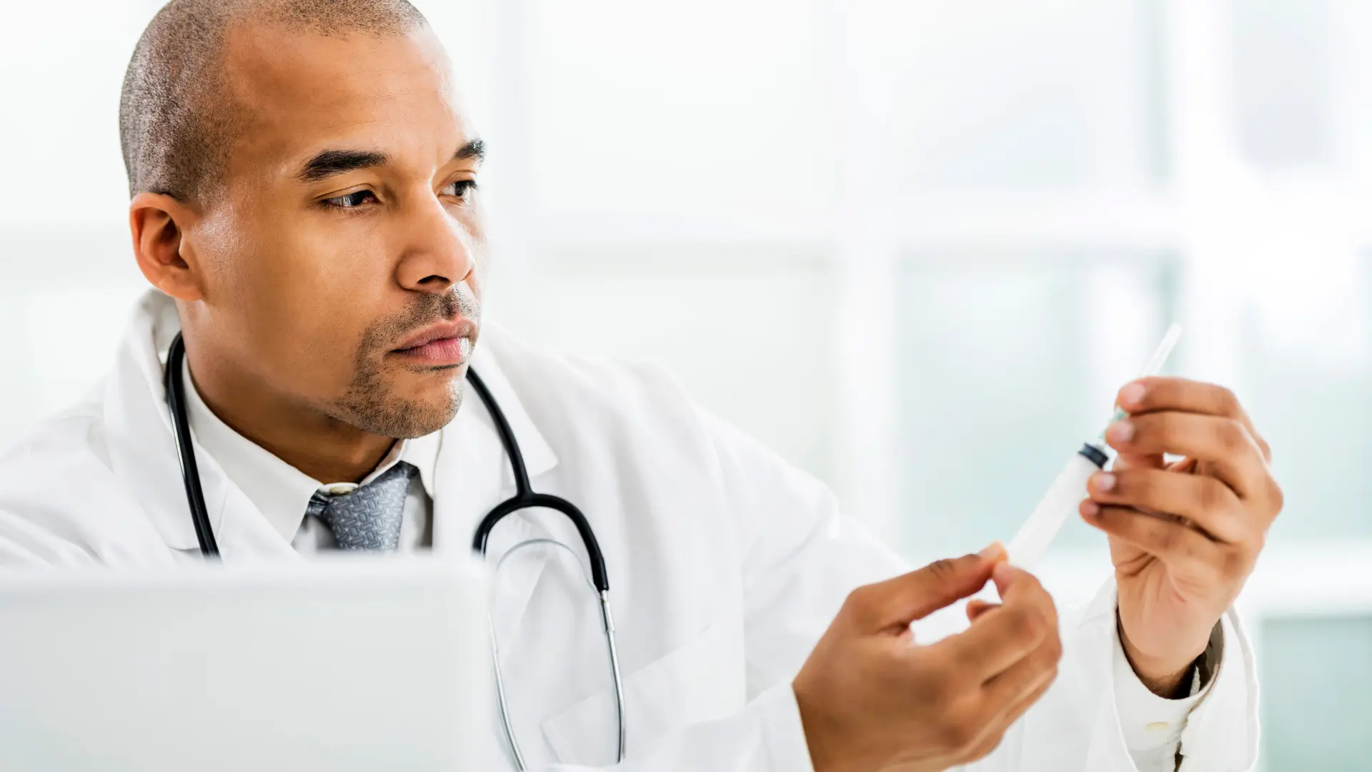 A healthcare provider holding a medical syringe.