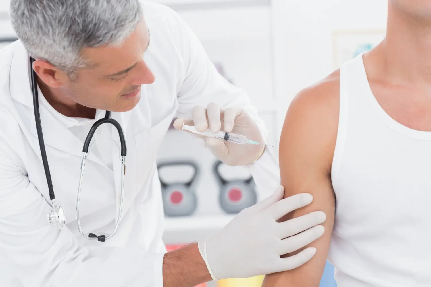 A medical professional administering a shoulder injection to a patient.