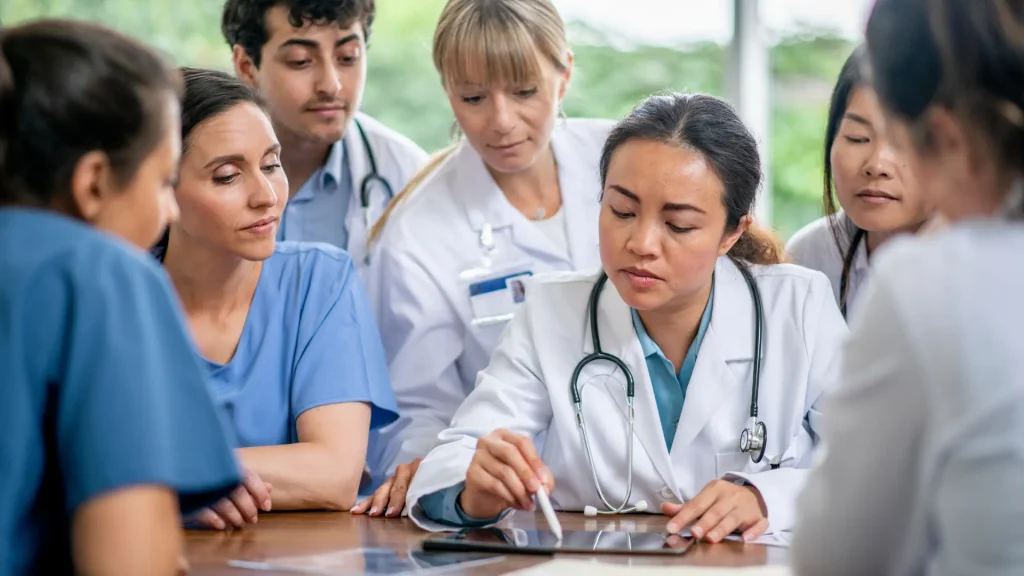 A group of medical professionals huddled together for a discussion.