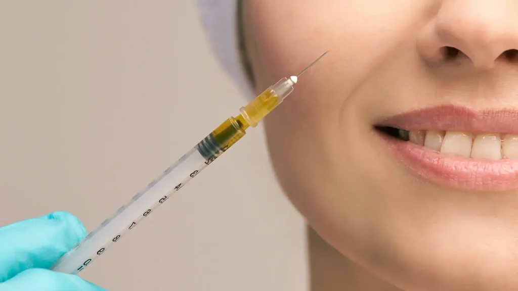 A patient smiling before undergoing a facial injection treatment.