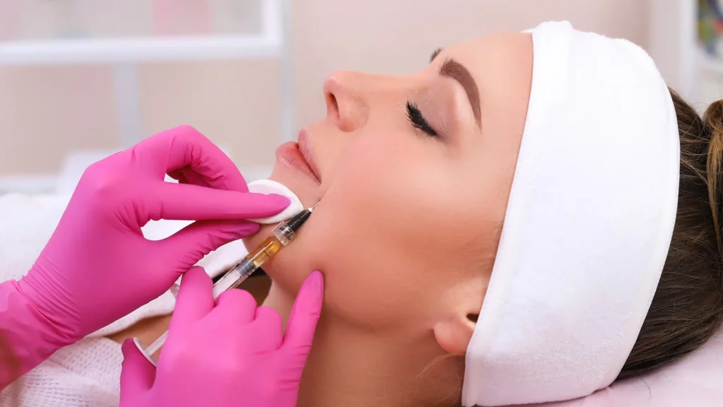 A healthcare provider administering an injection to the patient's facial aging signs.