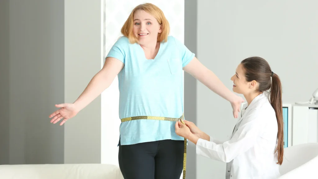 A medical professional measuring the patient's waist.