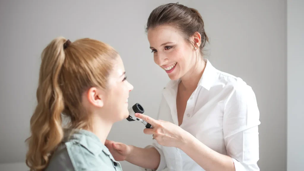 A healthcare provider examining a patient's facial regions.