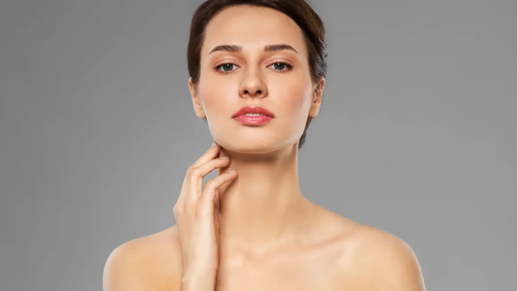 An individual flexing a smooth neck area after Sculptra for neck treatment.