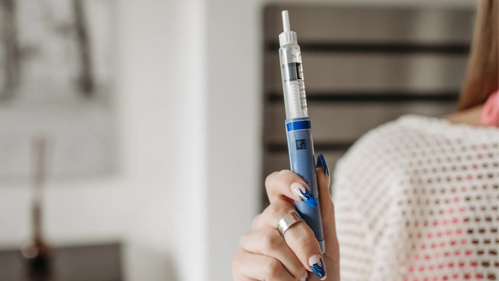 An individual holding an injectable pen for weight loss management.