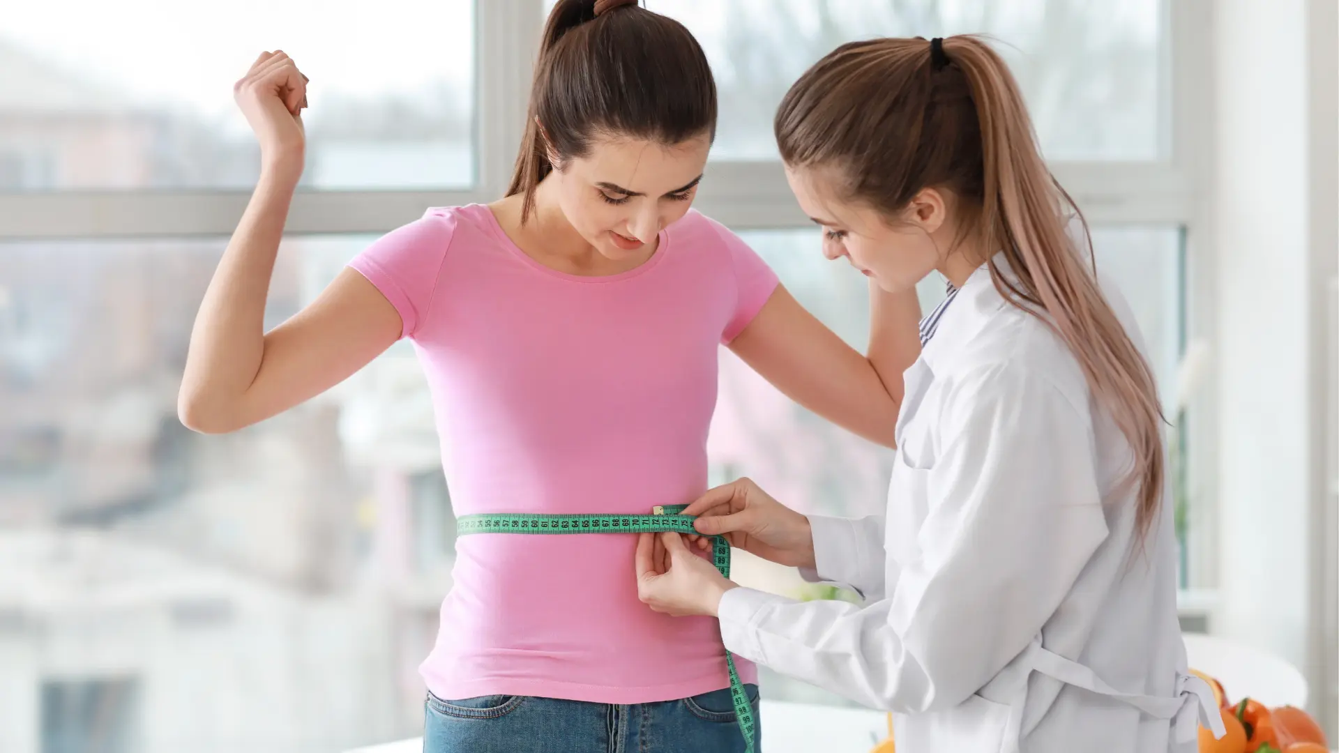 A healthcare professional measuring the patient's waist.