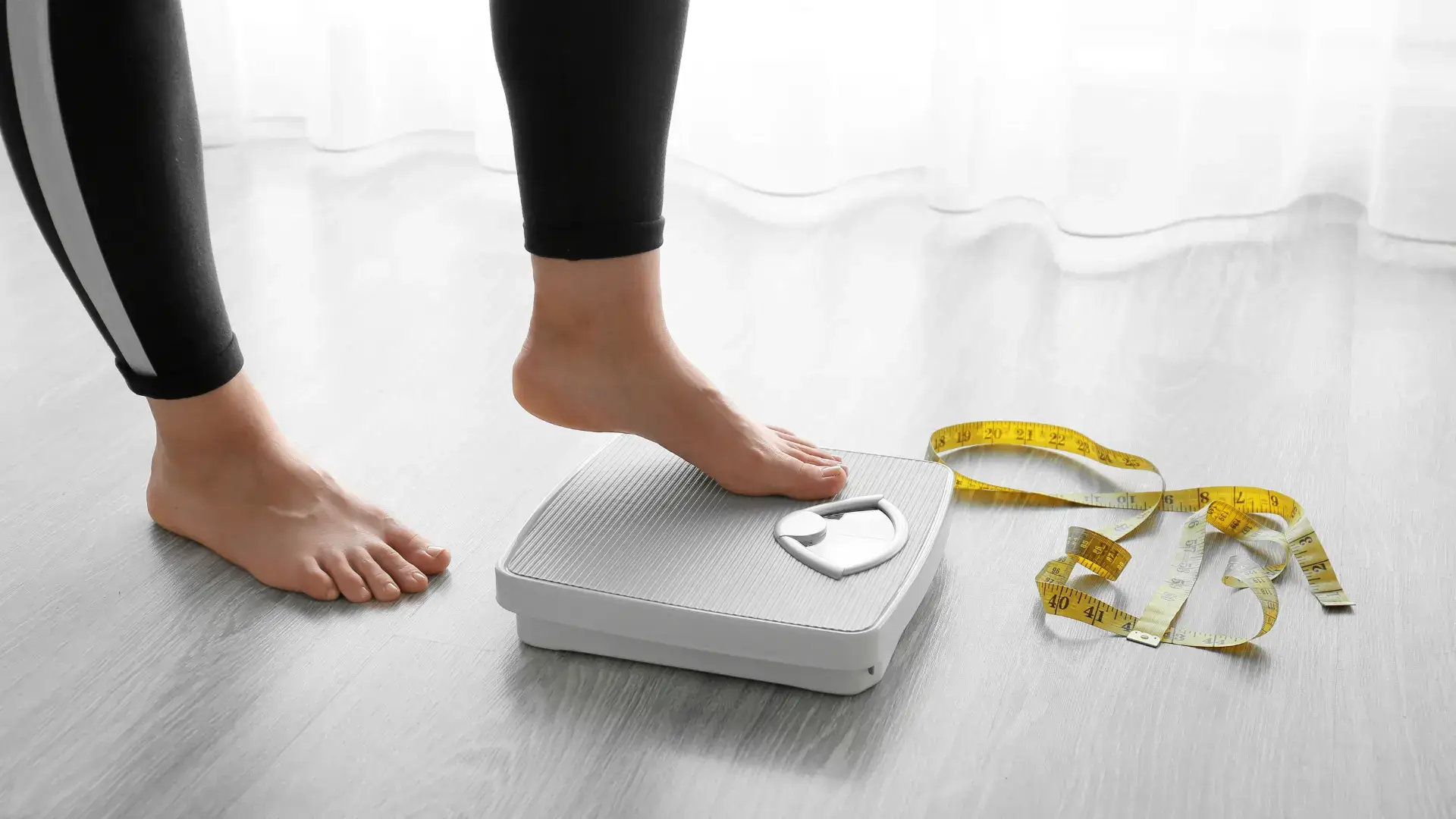 An individual checking their weight in the scale.