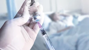 A medical professional preparing an injection for a patient.