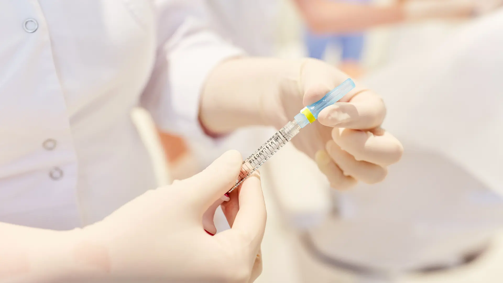 A medical professional preparing an injection for treatment.