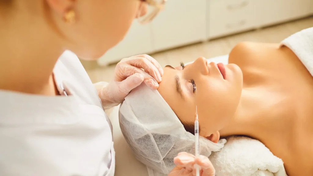 A medical professional administering a facial injection to a patient.