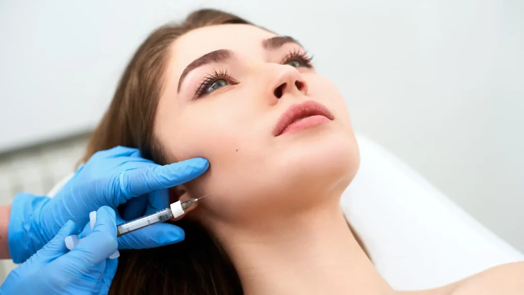 An aesthetic practitioner administering a patient's Sculptra jowls treatment.